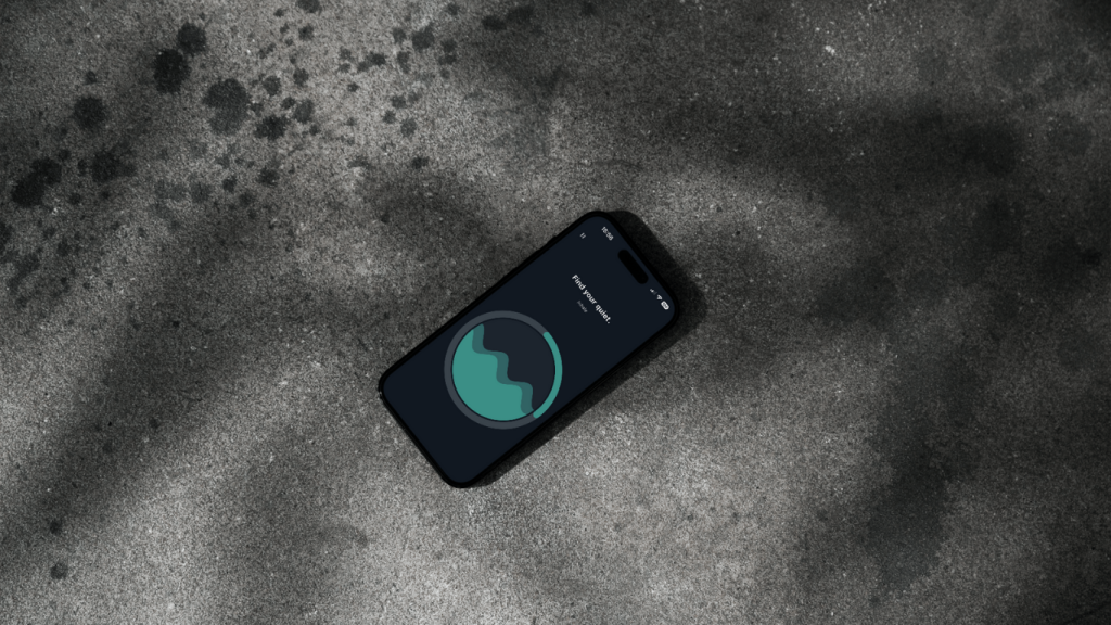 A smartphone displaying the QuietLine app on a dark, textured surface